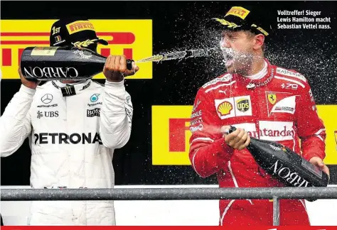  ??  ?? Volltreffe­r! Sieger Lewis Hamilton macht Sebastian Vettel nass.