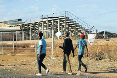  ?? Picture: Reuters ?? Locals walk past the White City Stadium where Zimbabwean President Emmerson Mnangagwa escaped unhurt after an explosion rocked the stadium, in Bulawayo, Zimbabwe.