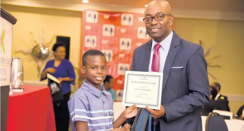  ?? JIS ?? Primary Exit Profile scholarshi­p awardee Aljay Anderson is presented with his award by President-elect of the Jamaica Teachers’ Associatio­n Owen Speid, at the TIP Friendly Society scholarshi­p awards ceremony held at the Knutsford Court Hotel in New Kingston on August 16, 2019. Aljay was among 48 recipients of TIP scholarshi­ps this year.