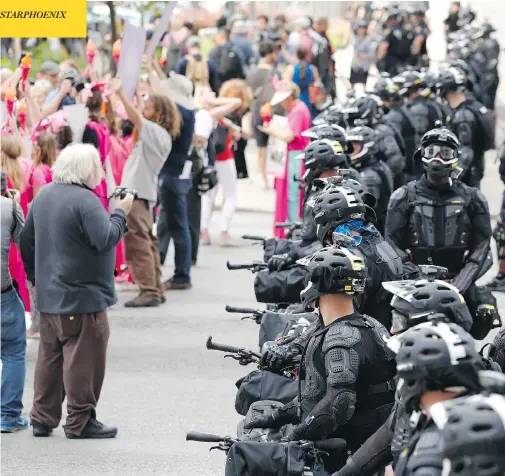  ?? ALEX BRANDON / THE ASSOCIATED PRESS ?? Demonstrat­ors march past police Sunday in downtown Cleveland, where the Republican National Convention begins on Monday. While many of the protesters had their own specific causes, they were united in their opposition to the presumptiv­e GOP nominee,...