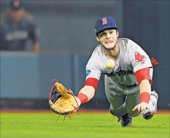  ?? Christophe­r Evans Boston Herald ?? ANDREW BENINTENDI makes a diving catch in left field with the bases loaded for the final out in Boston’s Game 4 win over Houston. The Astros’ Jose Altuve was denied a homer in the first inning and was called out after a replay ruled that a fan who reached for the ball interfered with Mookie Betts’ ability to catch it.