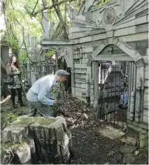  ??  ?? Valentina Salas and Philippe Spurrell check out a knight’s tomb at the annual garden party thrown by Ivan Dow and Joelle Crane. “I always wanted a forest in my backyard — and wanted it to have little ruins in it,” Dow says.
