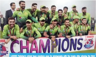  ?? — AFP ?? LAHORE: Pakistan’s cricket team members pose for photograph­s with the trophy after winning the third and final T20 cricket match against Sri Lanka, at the Gaddafi Cricket Stadium, in Lahore.