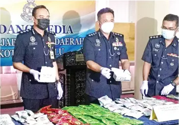  ??  ?? Habibi (centre) holding the drug known as “mushroom” at a press conference yesterday.