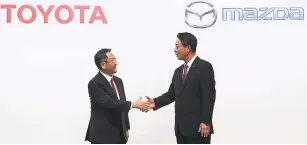  ?? AP ?? In this August 4, 2017 file photo, Toyota Motor Corp President Akio Toyoda, left, and Mazda Motor Corp. President Masamichi Kogai shake hands after a press conference in Tokyo.