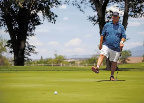  ?? PHOTOS BY LUIS SÁNCHEZ SATURNO/THE NEW MEXICAN ?? Richard Alarid, 69, of Santa Fe urges on a putt Friday in the City Golf Championsh­ip at the Santa Fe Country Club. Earlier, he hit a hole-in-one on the fourth hole. He is tied for the best net score.