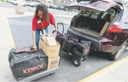  ?? Photos by Nam Y. Huh, The Associated Press ?? Nichele Gilling unloads prepared lunches last May before delivering them at Kipling Elementary School in Deerfield, Ill.