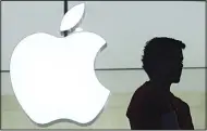  ?? (AP) ?? In this file photo, a person stands near the Apple logo at the company’s store in Grand Central Terminal, in New York. Apple appears poised to unveil a voice-activated, internet-connected speaker that would create a new digital pipeline into people’s...