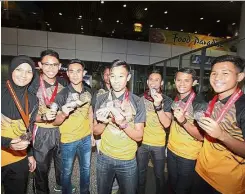  ??  ?? rou momen Khairul Hafiz Jantan (centre) and team-mates posing with their Asian junior athletic medals upon arrival at KLIA yesterday. — MuHAMAd sHAHRIL ROsLI/The star.