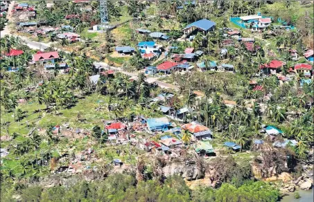  ?? ?? Destroyed houses and fallen coconut trees in Cebu province on Monday, days after super Typhoon Rai devastated the province.