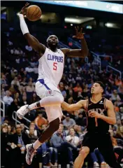  ?? ASSOCIATED PRESS ?? LOS ANGELES CLIPPERS’ Montrezl Harrell (5) drives past Phoenix Suns’ Devin Booker during Friday’s game in Phoenix.