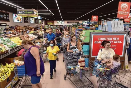  ?? Arnold Gold/Hearst Connecticu­t Media file photo ?? Shoppers browse in the produce aisle and wait in line to check out at the newly opened Aldi grocery store in Branford in 2022.