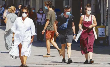  ?? REUTERS ?? People make their way amid the coronaviru­s outbreak in Barcelona, Spain yesterday.