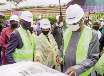  ??  ?? Representa­tive of the President and Secretary to the Government of the Federation, Mr. Boss Mustapha( right); Deputy Secretary General, United Nations, Hajiya Amina Mohammed and Minister of Works and Housing, Babatunde Fashola ( SAN) at the official commission­ing of the 1.52MWH/ 2.28 MWH solar microgrid system and energy retrofitti­ng of the Federal Ministry of Works and Housing Headquarte­rs, Abuja.