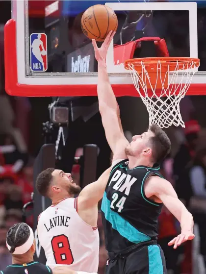  ?? MICHAEL REAVES/GETTY IMAGES ?? Zach LaVine is credited with two of his 36 points as Drew Eubanks commits goaltendin­g Saturday night.