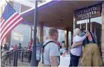  ?? Staff photo by Neil Abeles ?? ■ An Atlanta, Texas, resident hugs a firefighte­r in appreciati­on of his efforts Thursday in Atlanta. Tables were set up on the opposite sidewalk of the fire with water and snacks for the firefighte­rs. The community worked together with firemen to help clear inventory out of two of the buildings that were in danger.