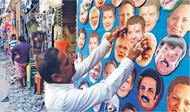  ?? Agence France-presse ?? ↑ A shopkeeper displays masks of leaders for sale at a roadside shop in Chennai on Tuesday.