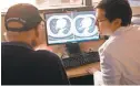  ?? AFP/GETTY IMAGES ?? Christian Hinrichs, right, an investigat­or at the National Cancer Institute, shows Fred Janick his CT scan in Bethesda, Md.