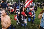  ?? JOHN LOCHER / ASSOCIATED PRESS ?? Right-wing demonstrat­ors kneel in prayer at Saturday’s Portland rally, which attracted fewer than originally expected.