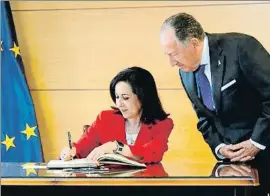  ?? CHEMA MOYA / EFE ?? La ministra firma en el libro de honor; Sanz Roldán observa atento