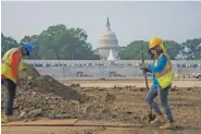  ?? AP PHOTO/J. SCOTT APPLEWHITE ?? Workers repair a park near the Capitol in Washington on Wednesday.