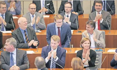  ?? FOTO: DPA ?? Moritz Körner (Mitte) wurde offiziell als das mit 26 Jahren jüngste Landtagsmi­tglied begrüßt. Die Abgeordnet­enrunde applaudier­te, Moritz Körner verbeugte sich.