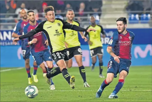  ??  ?? Jorge intenta robar el balón a Miguelón, que asistió a Mikel Rico en el primer gol del Huesca y marcó el segundo.