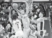  ?? Brandon Dill Associated Press ?? WAYNE SELDEN, one of eight Grizzlies who scored in double figures, shoots over Larry Nance Jr. of the Lakers.