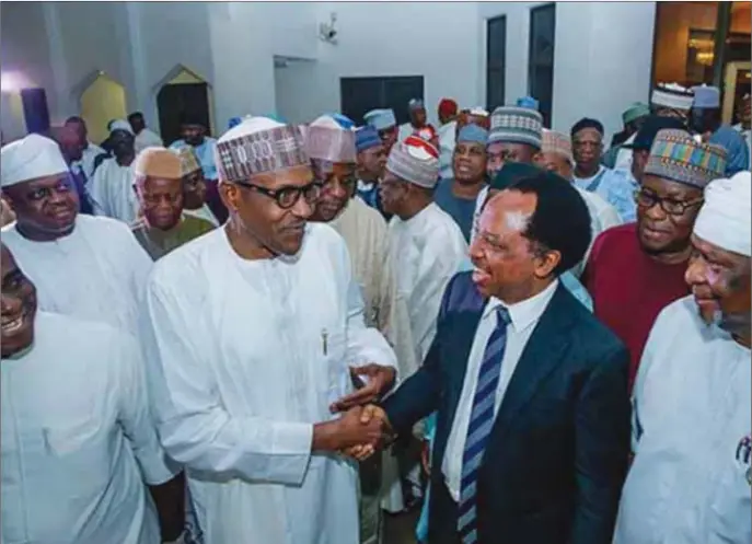  ??  ?? Buhari in a hearty chat with Senator Sheu Sanni after the president met with senators, as other senators watch in admiration