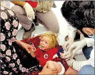  ?? AP/BALINT SZLANKO ?? A doctor cares for an Iraqi child believed to have food poisoning Tuesday at a camp for people displaced from war-torn Mosul. More than 700 people fell ill after a meal to break the Ramadan fast, Iraqi officials said Tuesday.