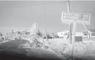  ??  ?? Downed power poles and an ice-covered sign are shown in Escuminac, N.B., on Jan. 27.