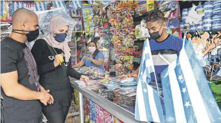  ?? JIMMY NEGRETE / EXPRESO ?? Celebració­n. Toula Soleiman, una turista del Líbano, compra los adornos de la fiesta de Guayaquil para festejar el cumpleaños de su hija.