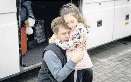  ?? LEON NEAL/GETTY ?? Eugene Yevchenko cries as he hugs his daughter before she boards a train for Poland on Saturday in Lviv.