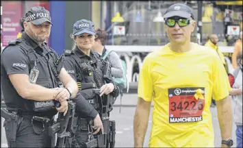  ?? RUI VIEIRA / ASSOCIATED PRESS ?? Armed response police guard the scene at the Great Manchester Run in central Manchester, England, on Sunday.