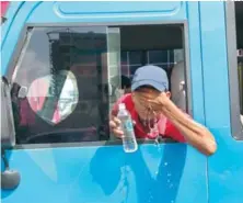  ?? ARCHIVO ?? Un camionero se refresca con una botella de agua fría.