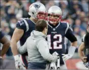  ?? DAVID J. PHILLIP — THE ASSOCIATED PRESS ?? New England Patriots quarterbac­k Tom Brady (12) watches as tight end Rob Gronkowski, left, is assisted from the field after a hit by Jaguars safety Barry Church during the AFC Championsh­ip game last Sunday.