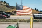  ?? RYAN DAVID BROWN THE NEW YORK TIMES ?? An American flag flies Saturday outside a country store in Pine, Colo. Reporters asked people at roadside restaurant­s, outlet stores and rest stops in Colorado, Georgia and New Hampshire how they are feeling about America on its birthday.