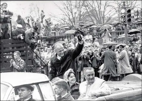  ?? GEORGE TAMES / THE NEW YORK TIMES ?? John Glenn waves to well-wishers as he is joined by his wife, Annie, and Vice President Lyndon B. Johnson (right) during a parade in Washington in 1962, days after Glenn’s historic flight into space. Glenn, who was hailed as a national hero and a...