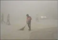  ?? R S IYER — THE ASSOCIATED PRESS ?? Indian workers use brooms to sweep away dust in the morning fog in Greater Noida, near New Delhi, India, Friday, Nov.10.