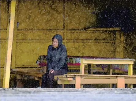  ?? Wally Skalij Los Angeles Times ?? A MAN in Ensenada takes shelter as Hilary hit Baja California on Saturday. Some Tijuana residents shrugged off the storm’s dangers.