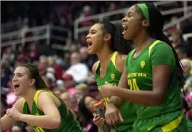  ?? Associated Press ?? Oregon’s Sabrina Ionescu, from left, Satou Sabally and Ruthy Hebard celebrate in the last minute of a 40-point rout of Stanford Sunday.