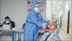  ??  ?? A health worker collects the swab sample of a resident of Kasarvadav­li in Thane during a Covid-19 testing camp on Saturday.