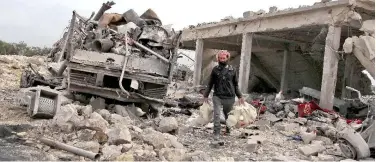  ?? Agence France-presse ?? ↑
A Syrian man carries dead chickens found under the rubble of a building following airstrikes in Maaret Misrin on Thursday.