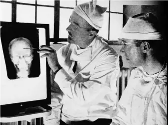  ??  ?? Walter Freeman (left) and James Watts study an X-ray prior to conducting ‘psychosurg­ery’
