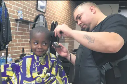  ?? RICHARD PAYERCHIN — THE MORNING JOURNAL ?? Barber William Quinones cuts the hair of Aking Brown, 3, on Oct. 4 at Headlinerz Barbershop, 2259 E. 42nd St., South Lorain.