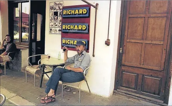  ?? ARCHIVO. ?? Richard Hamilton sentado en el bar Melitón de Cadaqués, delante del cartel metálico Richard, diseñado por él mismo