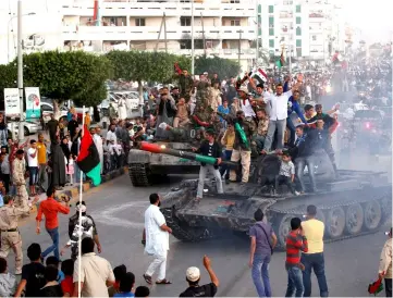  ??  ?? File photo shows anti-Gaddafi fighters returning from Sirte gesture to crowds welcoming them back in Misrata. — Reuters photo