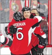  ?? JANA CHYTILOVA / GETTY IMAGES ?? Dion Phaneuf gets a hug from teammate Chris Wideman after scoring in overtime to lift Ottawa past Boston in the second game of the series.