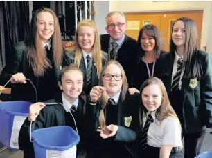  ??  ?? Team effort Holly with head teacher Eddie Morrison, mum Michelle, sister Gemma and classmates with charity collection buckets