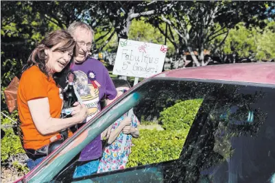  ?? Benjamin Hager Las Vegas Review-journal @benjaminhp­hoto ?? Laurie Grosenick and husband Gary Grosenick, teachers at Goolsby Elementary School, smile as friends, staff and students give them a drive-by retirement party Thursday at Ridgebrook Park. They taught together at Goolsby for the past 15 years.